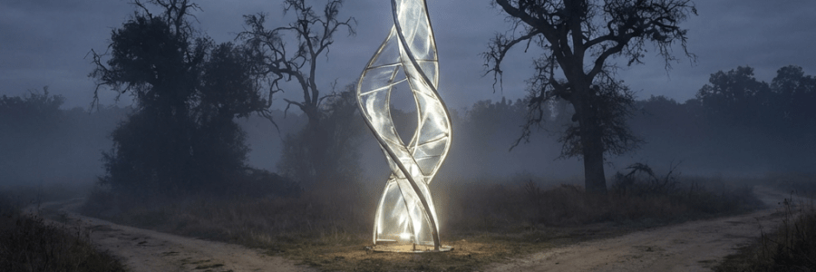 A luminous twisted sculpture stands at a crossroads in a misty forest at dusk.